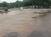 Kondisi ruas jalan dan jembatan yang diduga bagian dari proyek Riverside Road Project (RRP) di kawasan Antang, Makassar, tampak basah usai hujan, dengan pembatas darurat terpasang di lokasi yang disorot terkait dugaan pelanggaran lingkungan dan perizinan.