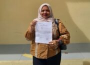 Pengacara Yulindawati menunjukkan surat tanda bukti laporan pengaduan (LP) usai melaporkan tiga akun media sosial ke Ditreskrimsus Polda Aceh.