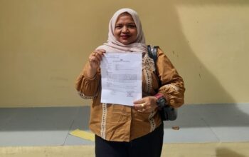 Pengacara Yulindawati menunjukkan surat tanda bukti laporan pengaduan (LP) usai melaporkan tiga akun media sosial ke Ditreskrimsus Polda Aceh.