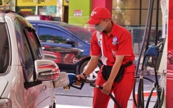 Petugas SPBU Pertamina saat melayani pengisian bahan bakar minyak (BBM) jenis Pertalite ke salah satu mobil konsumen