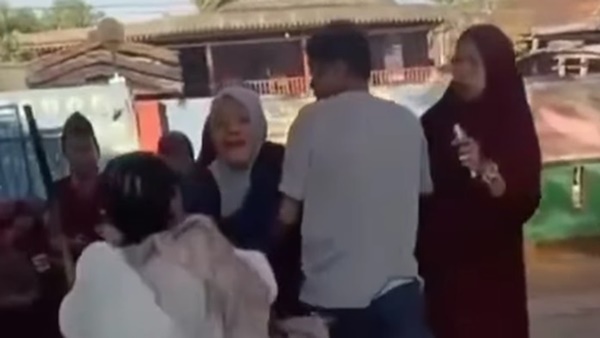 Tangkapan layar video memperlihatkan seorang guru berhijab dijambak dan diserang sejumlah orang tua murid di lingkungan sekolah, Jeneponto, Sulawesi Selatan.