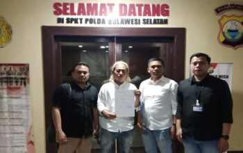 Ketua DPW Gibran Center Sulsel, M. Taufik Hidayat (memegang surat pengaduan, tengah), didampingi tim kuasa hukumnya saat mendatangi SPKT Polda Sulsel.