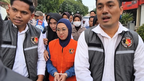 Mantan Bupati Gowa, Sitti Husniah Talenrang menggunakan rompi oranye dan kedua tangan diborgol tali tis usai keluar dari ruang penyidikan (Foto : Ist)
