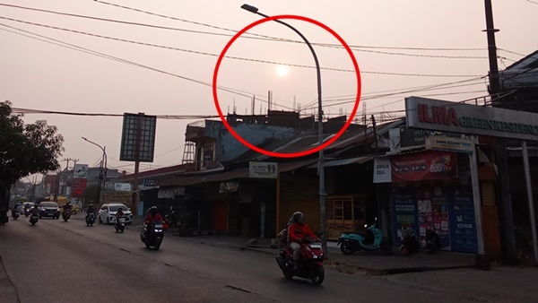 Pemandangan kabut asap tipis yang menyelimuti dan menutupi sinar matahari di sepanjang Jalan Toddopuli Raya Timur menuju arah Borong Raya, Makassar, Rabu (14/10/2026). Fenomena asap kiriman karhutla ini menyebabkan penurunan kualitas udara dan memicu kewaspadaan warga sekitar.
