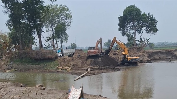 Dua unit alat berat ekskavator saat melakukan aktivitas pengerukan pasir galian C yang diduga berkaitan dengan operasional tambang tak berizin di Bontonompo, Gowa.